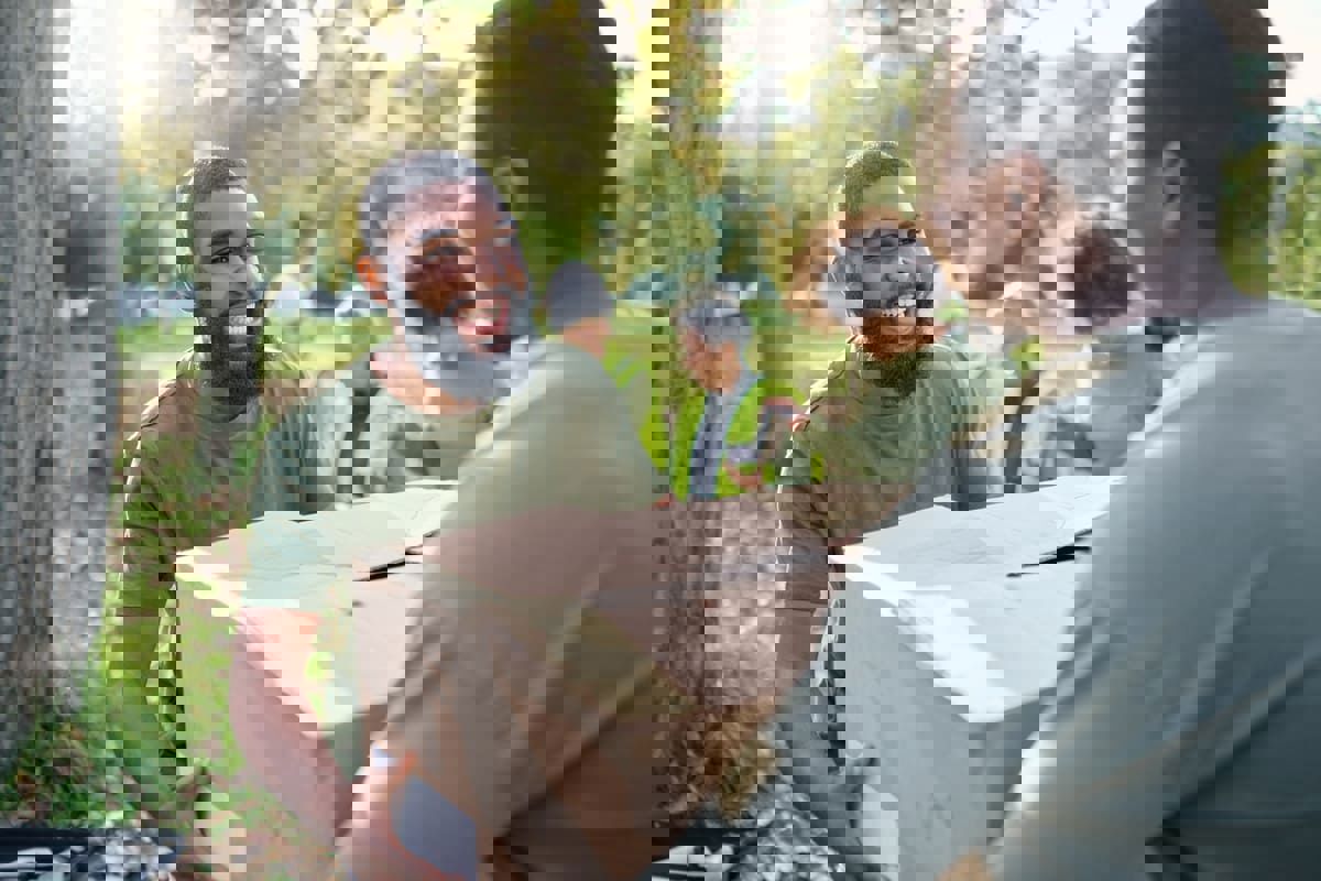 Volunteers carrying donation boxes, illustrating community support and charitable efforts.