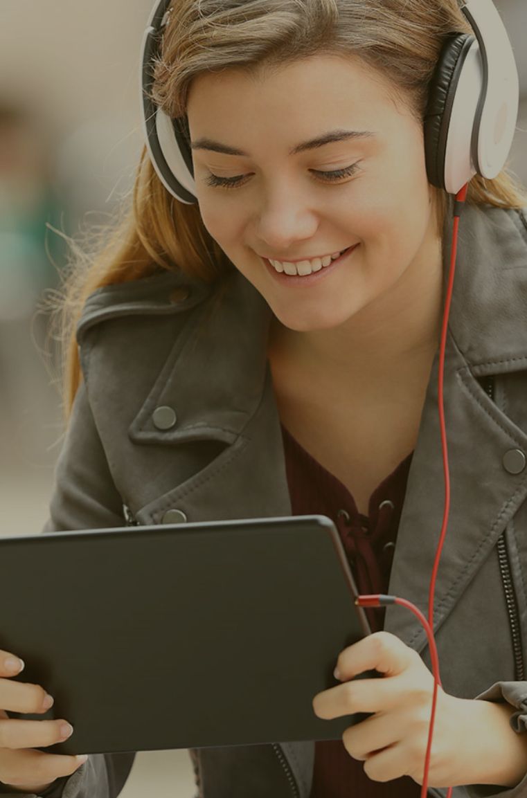 woman smiling with headset holding a tablet