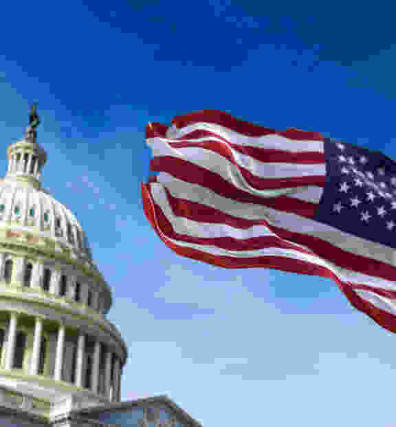 The U.S. Capitol building dome with the American flag prominently displayed, symbolizing national governance and public service initiatives.